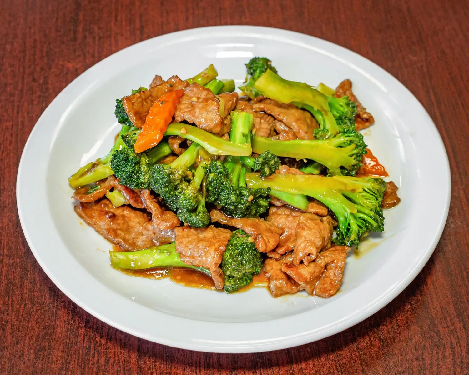 A plate of broccoli beef rice, with stir - fried broccoli and beef served over rice, in a white dish at Uncle Yu Restaurant，a Chinese Restaurant in Union City
