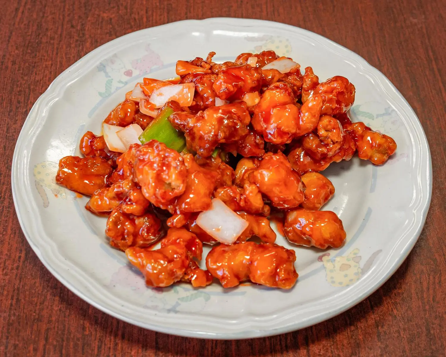 A plate of sweet and sour chicken rice, with tender chicken pieces in a sweet - sour sauce at Uncle Yu Restaurant，a Chinese Restaurant in Union City